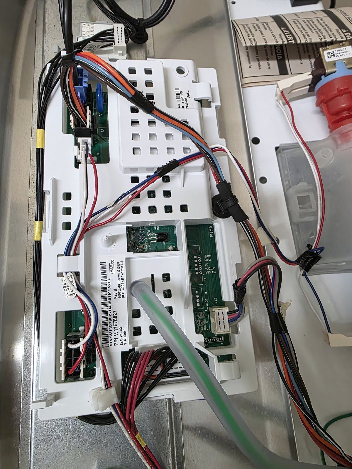 Appliance control panel and circuit boards connected to test leads during diagnosis