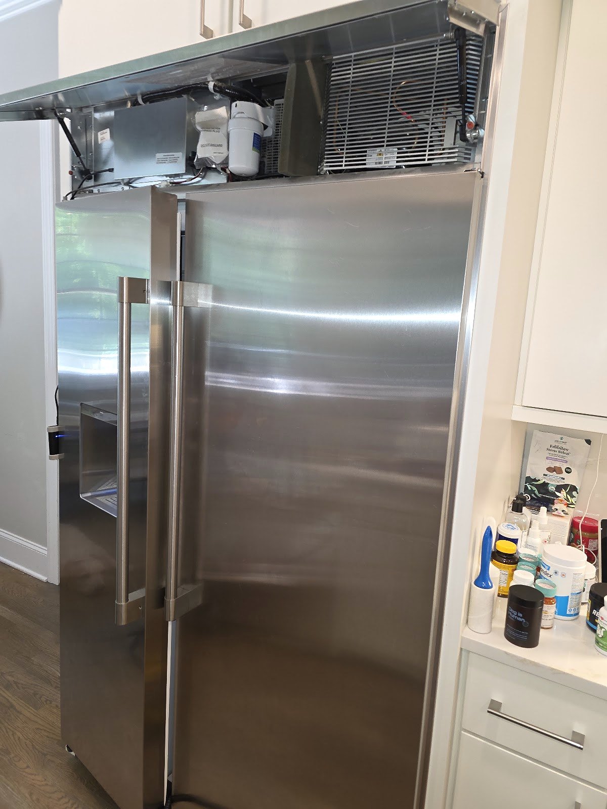 Built-in stainless steel refrigerator with the upper service compartment open