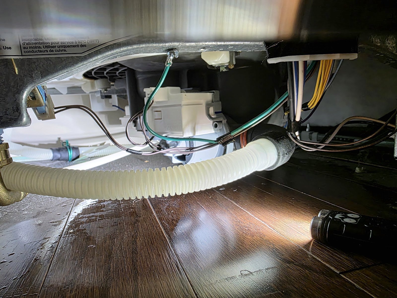 Dishwasher pump, hose and wiring visible beneath the wash tub