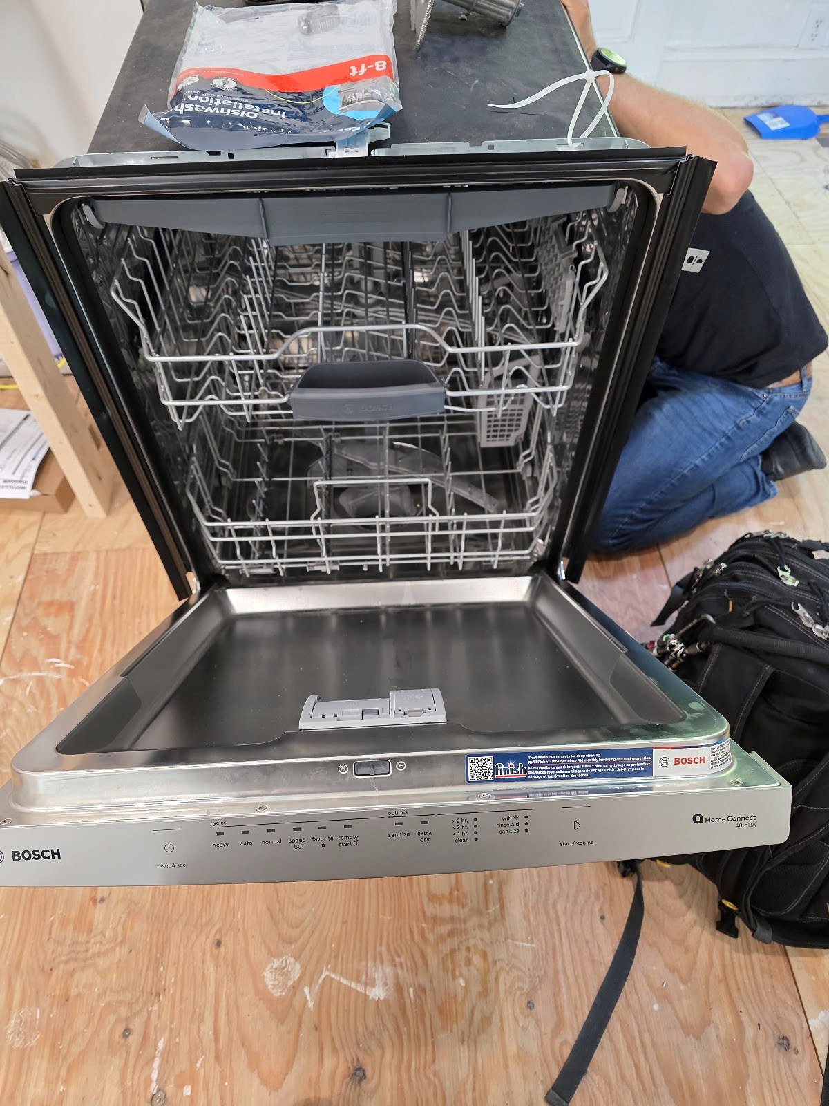 Open dishwasher with its racks exposed during service