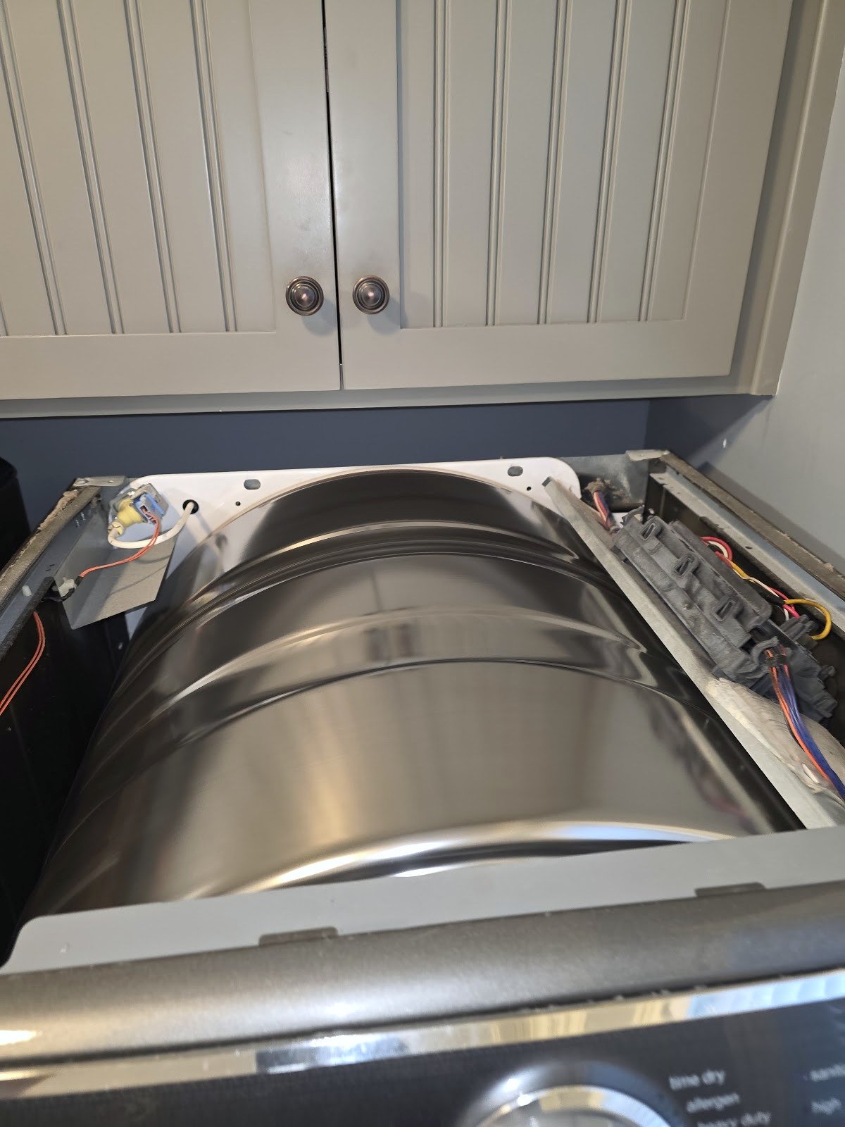 Dryer with its top panel removed and the drum exposed