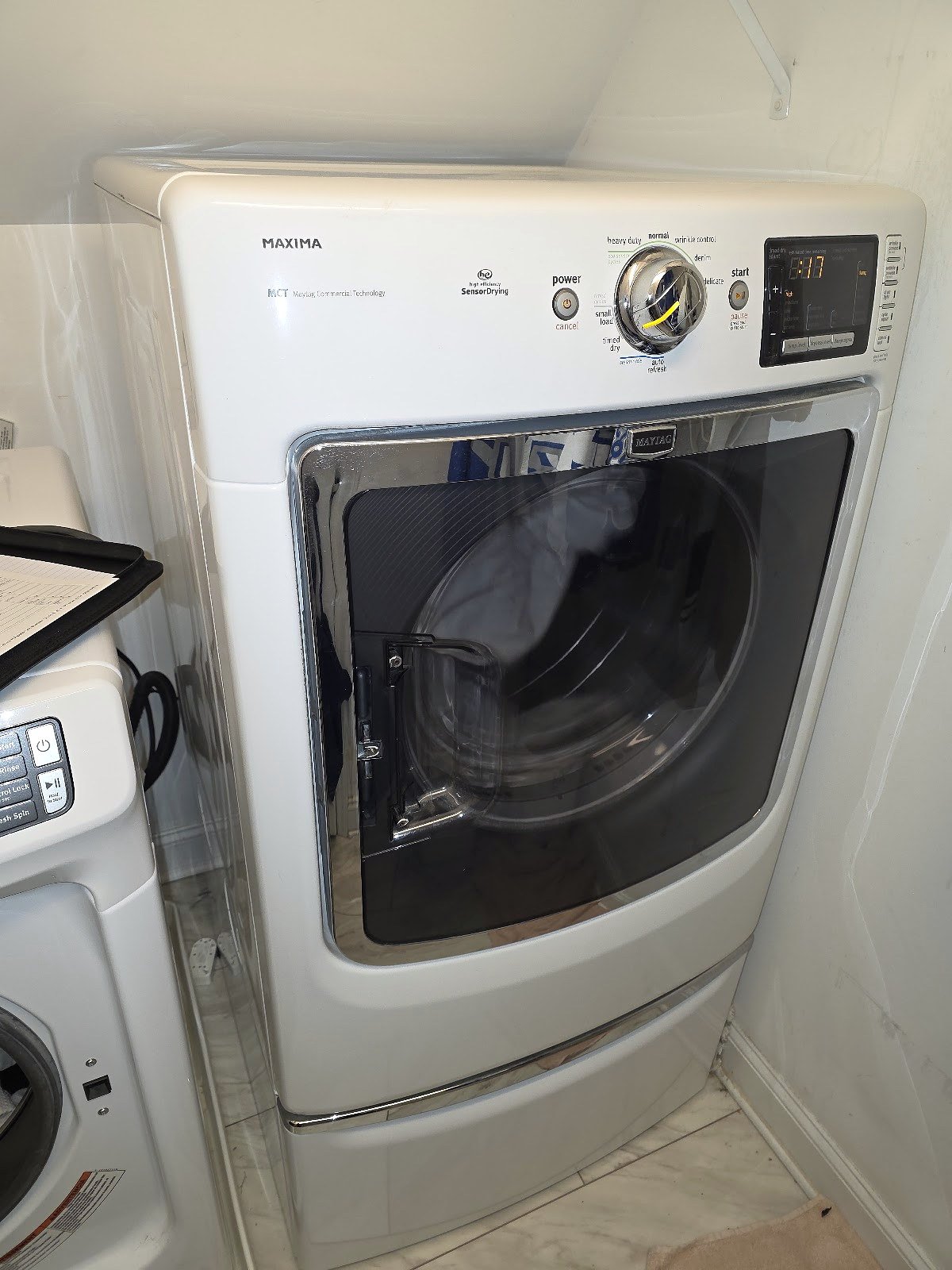 White front-load dryer with a large dark door and digital controls