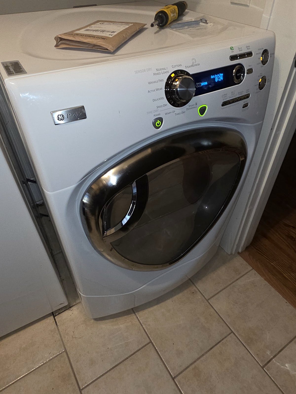 Silver front-load washing machine with an illuminated control panel