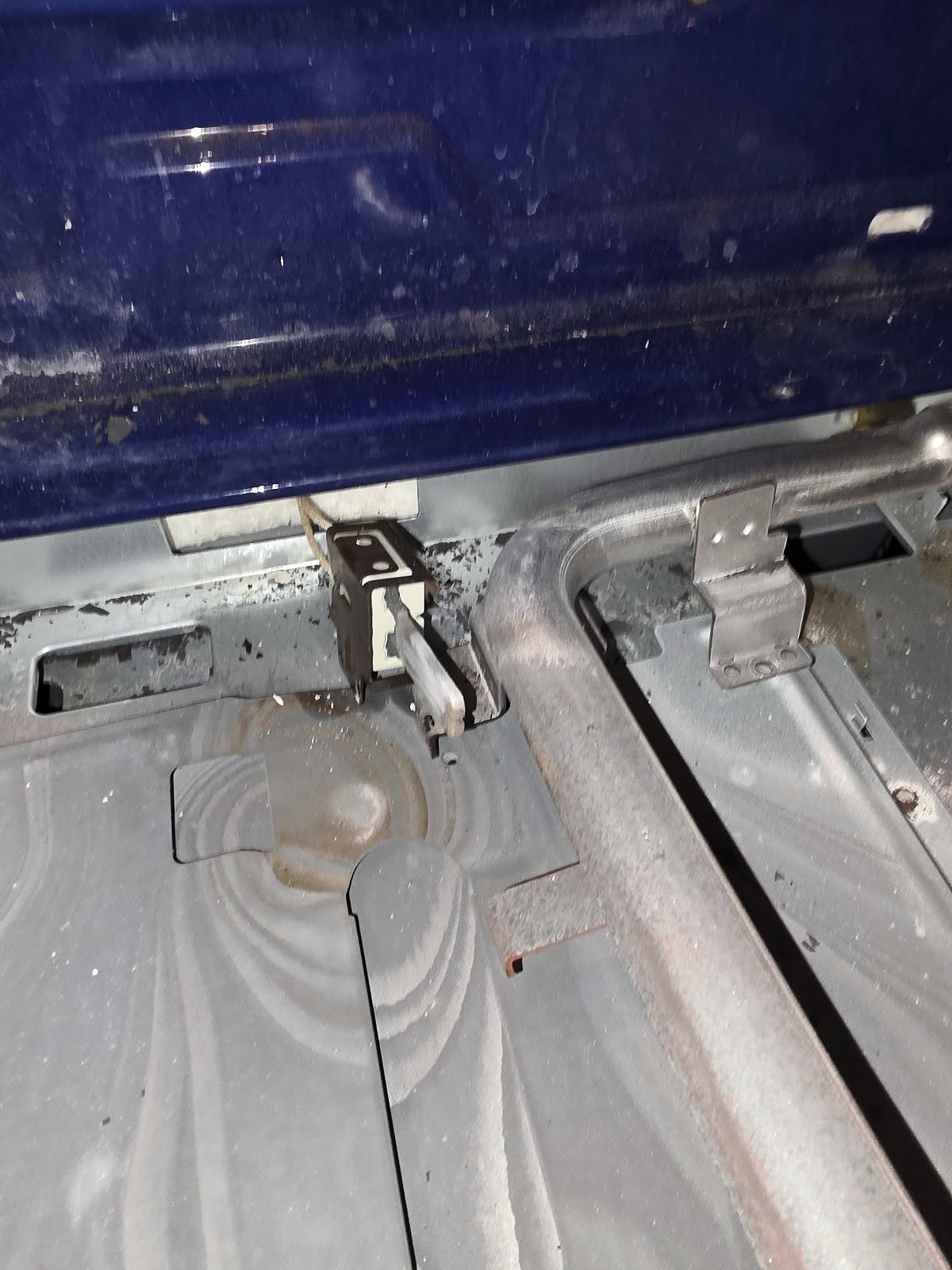 Gas oven with the lower cover removed to expose the burner and ignition area