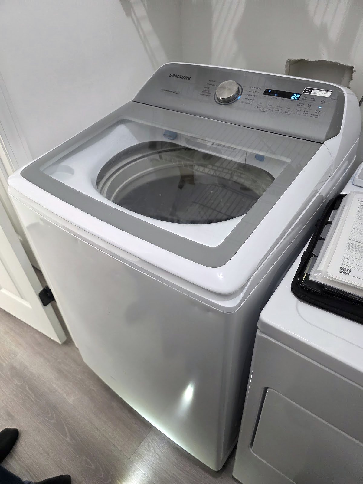 Top-load washing machine with a glass lid and rear controls