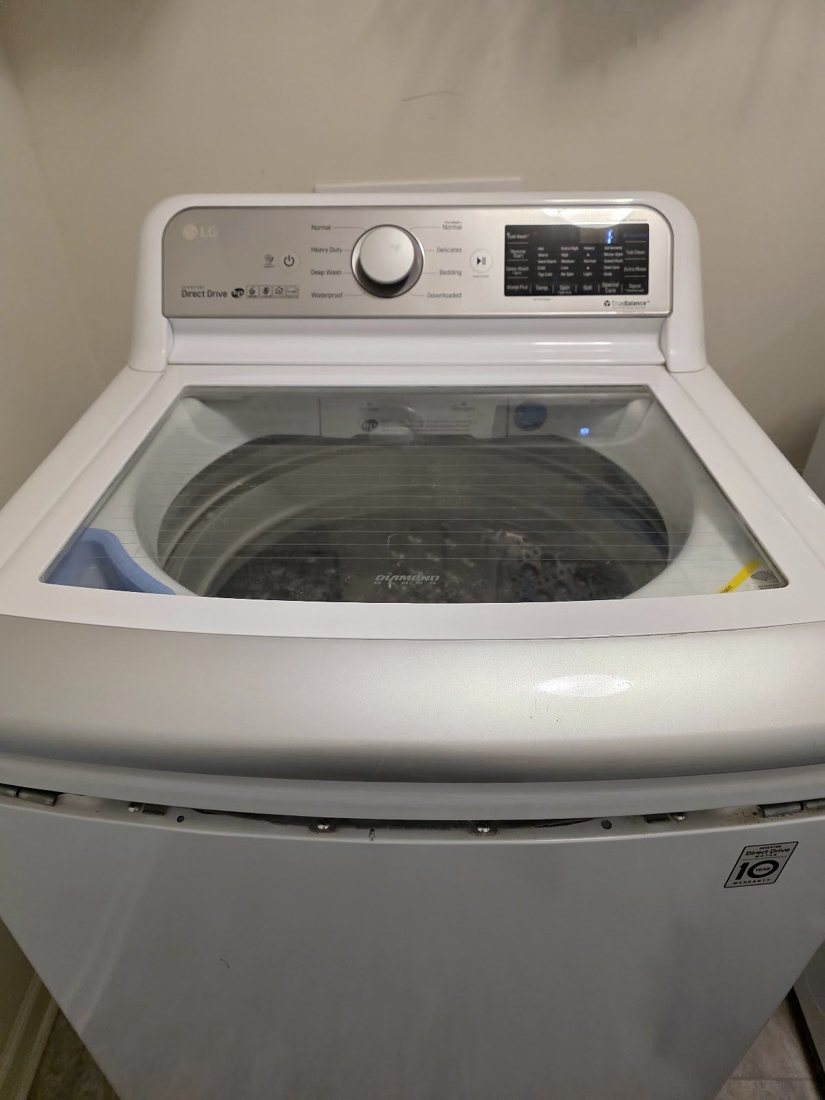 White LG top-load washer with a glass lid