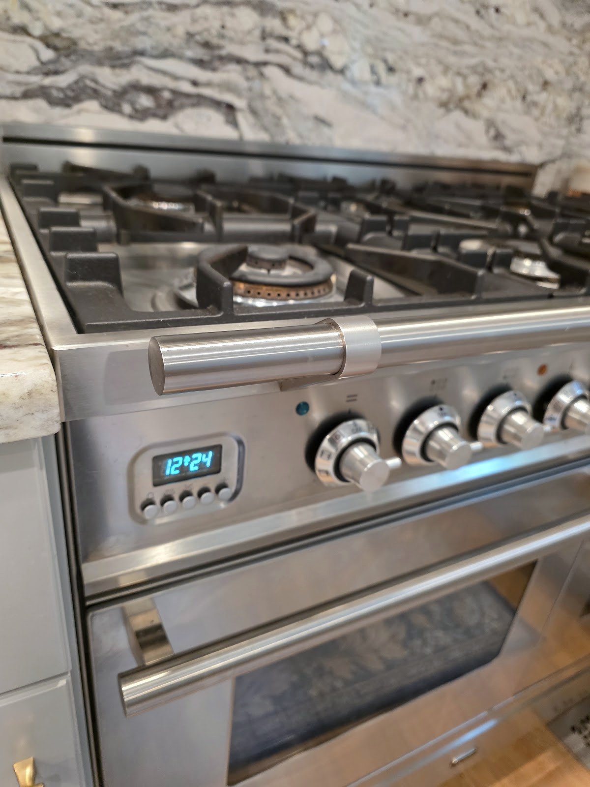 Front control knobs and gas burners on a stainless steel range