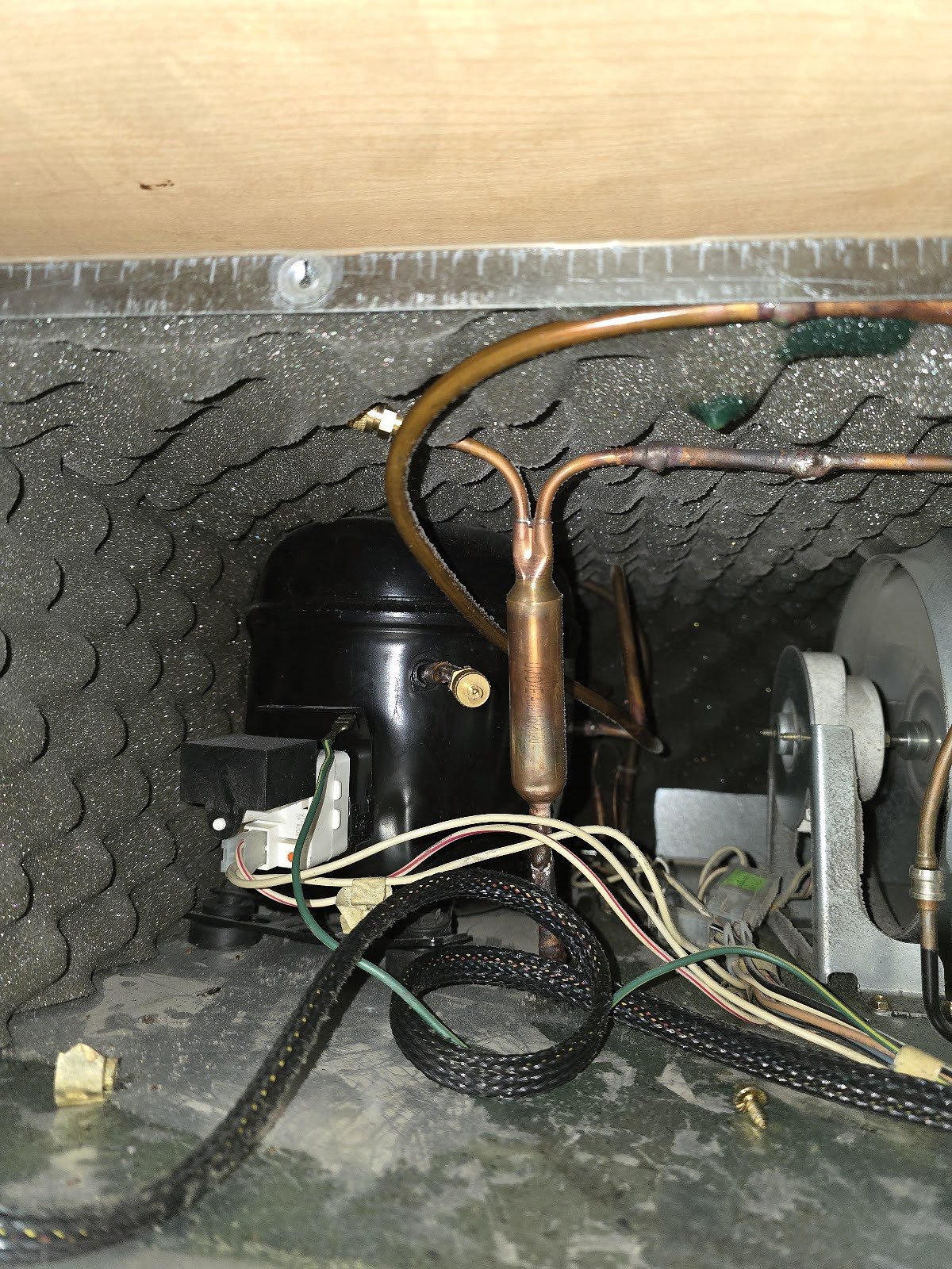 Refrigerator compressor compartment with copper tubing and electrical connections