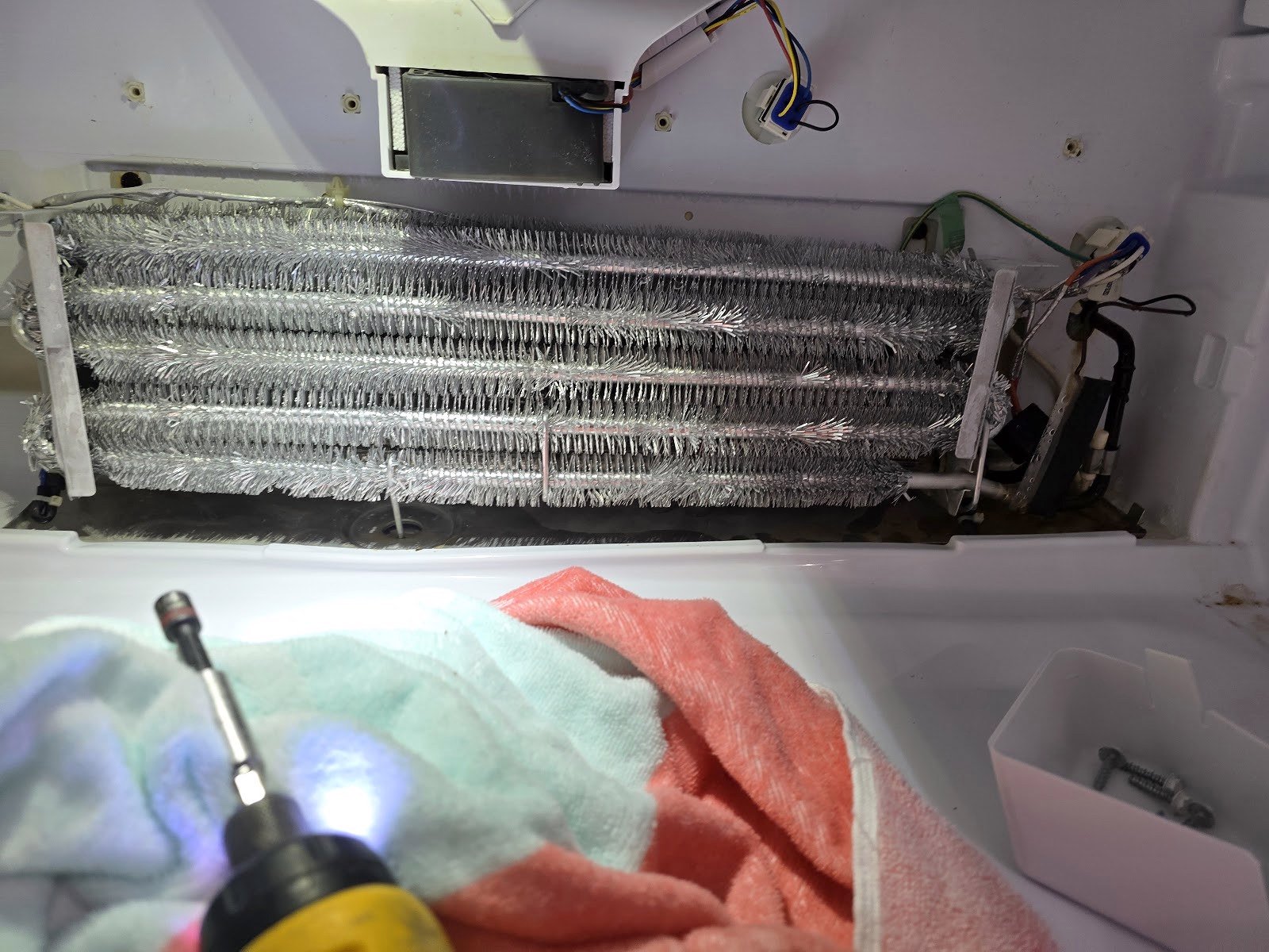 Refrigerator evaporator coil exposed during an in-home service visit