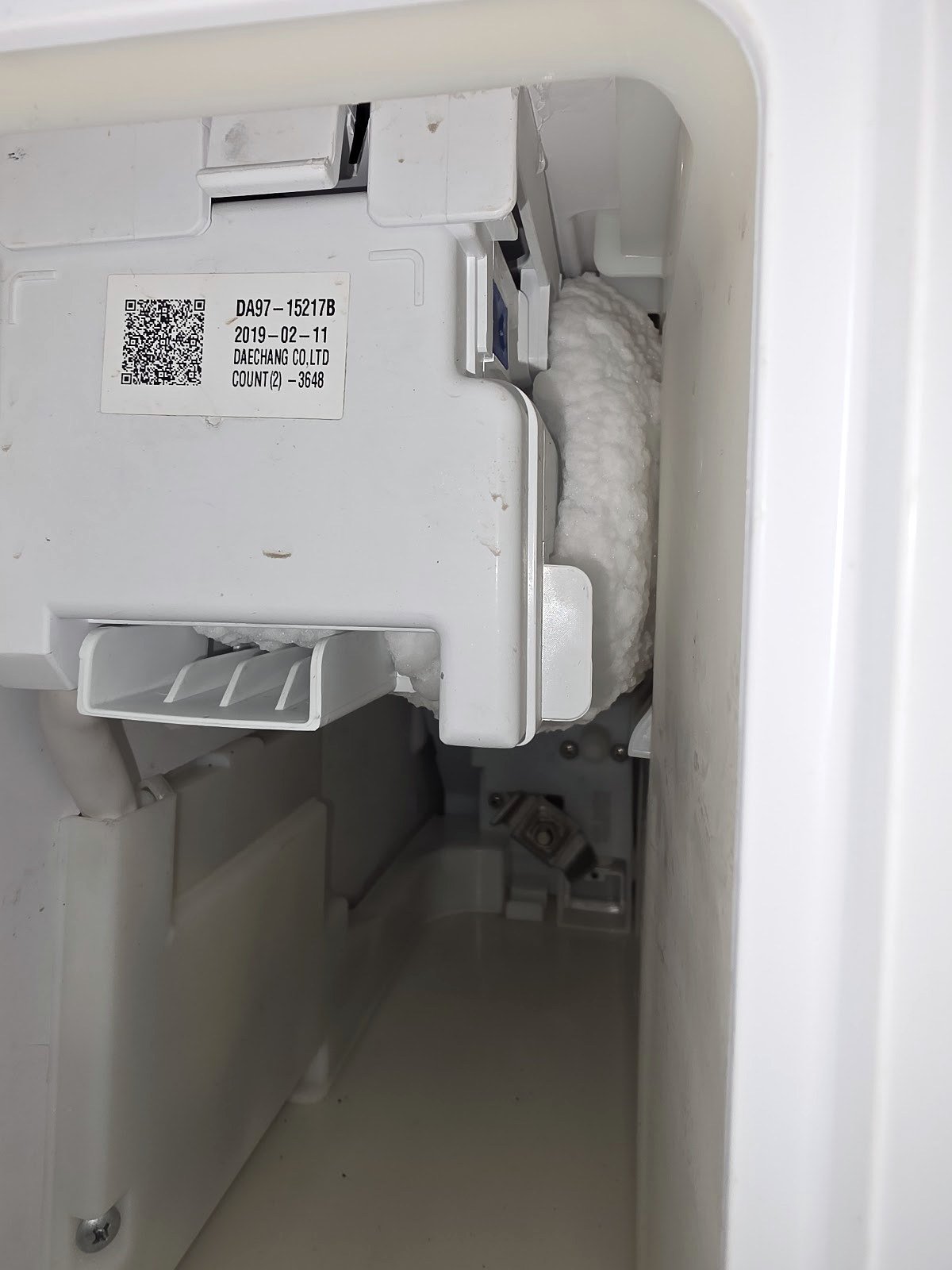 Refrigerator ice maker assembly with its front cover removed