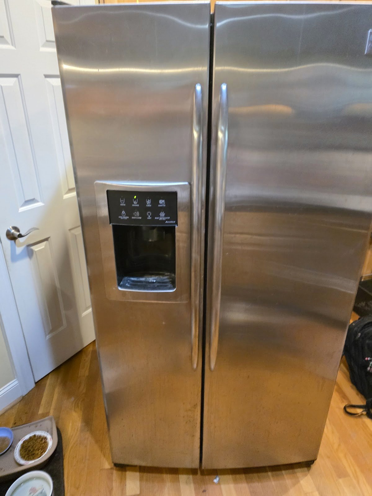 Stainless steel side-by-side refrigerator with a door dispenser