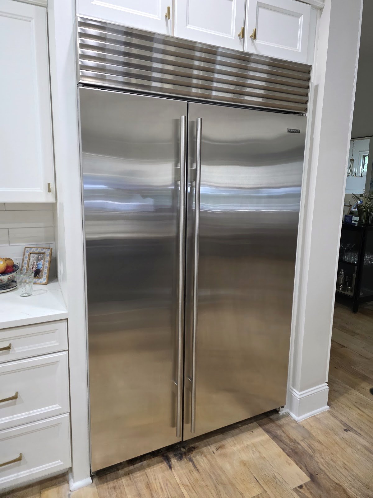 Stainless steel built-in refrigerator with a wide upper ventilation grille