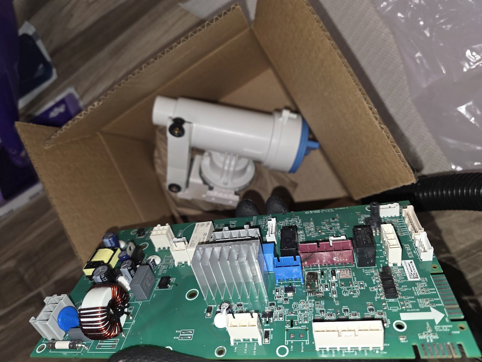 Washer circuit board and pump assembly laid out for inspection