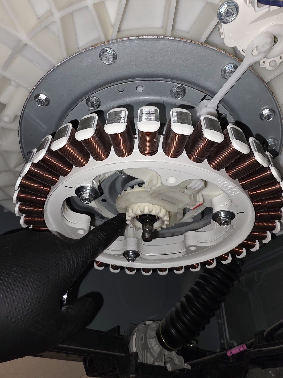 Exposed circular motor stator and wiring on a washing machine