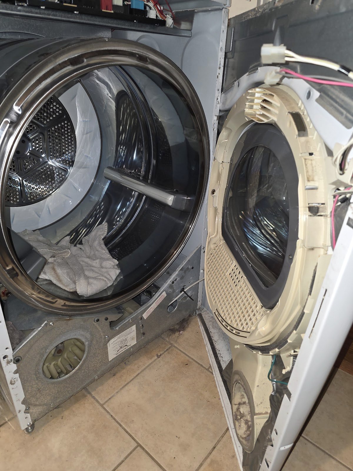 Front-load washer with its front panel removed to access the drum and door seal