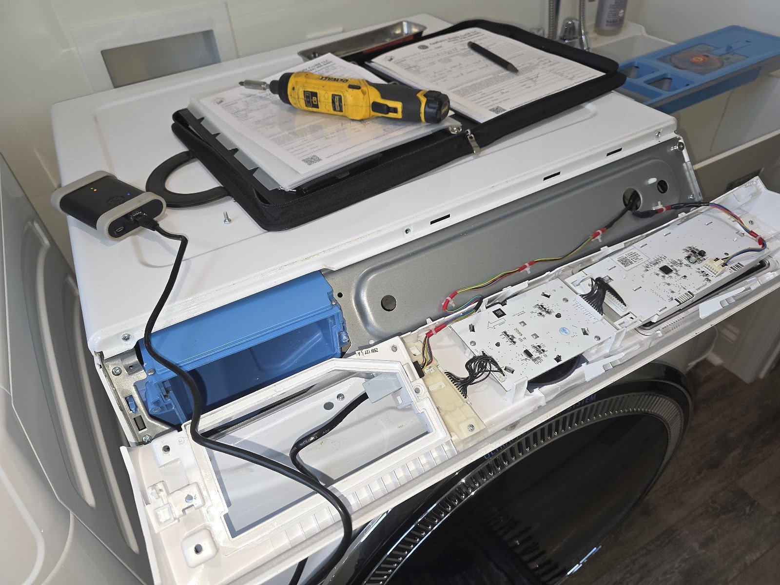 Front-load washing machine with its upper control panel opened for service