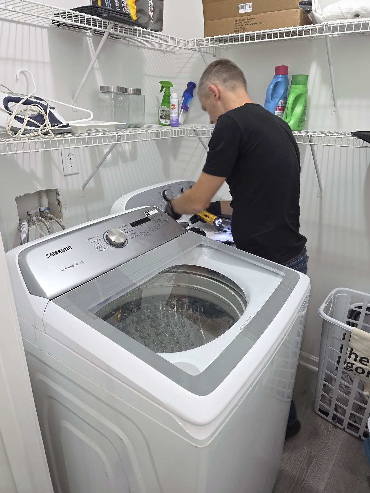 Technician inspecting a top-load washer control console