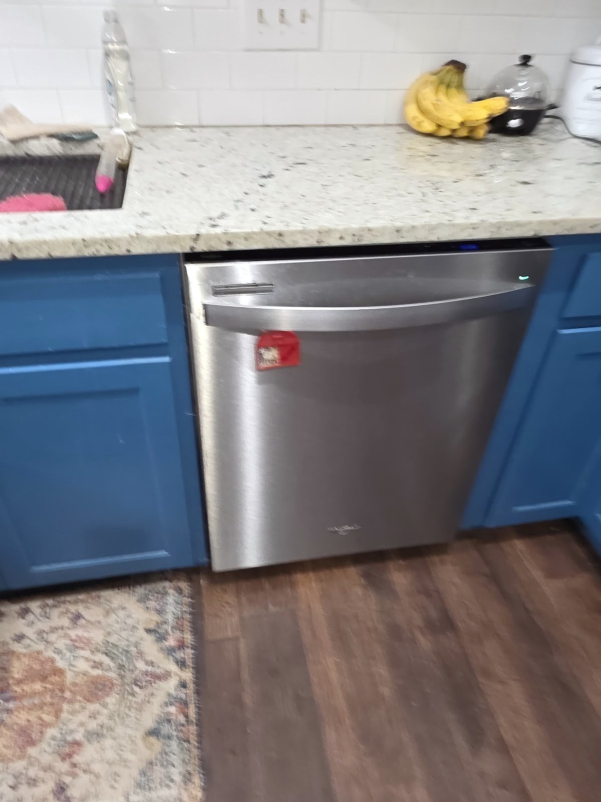 Stainless steel built-in Whirlpool dishwasher beneath a kitchen counter