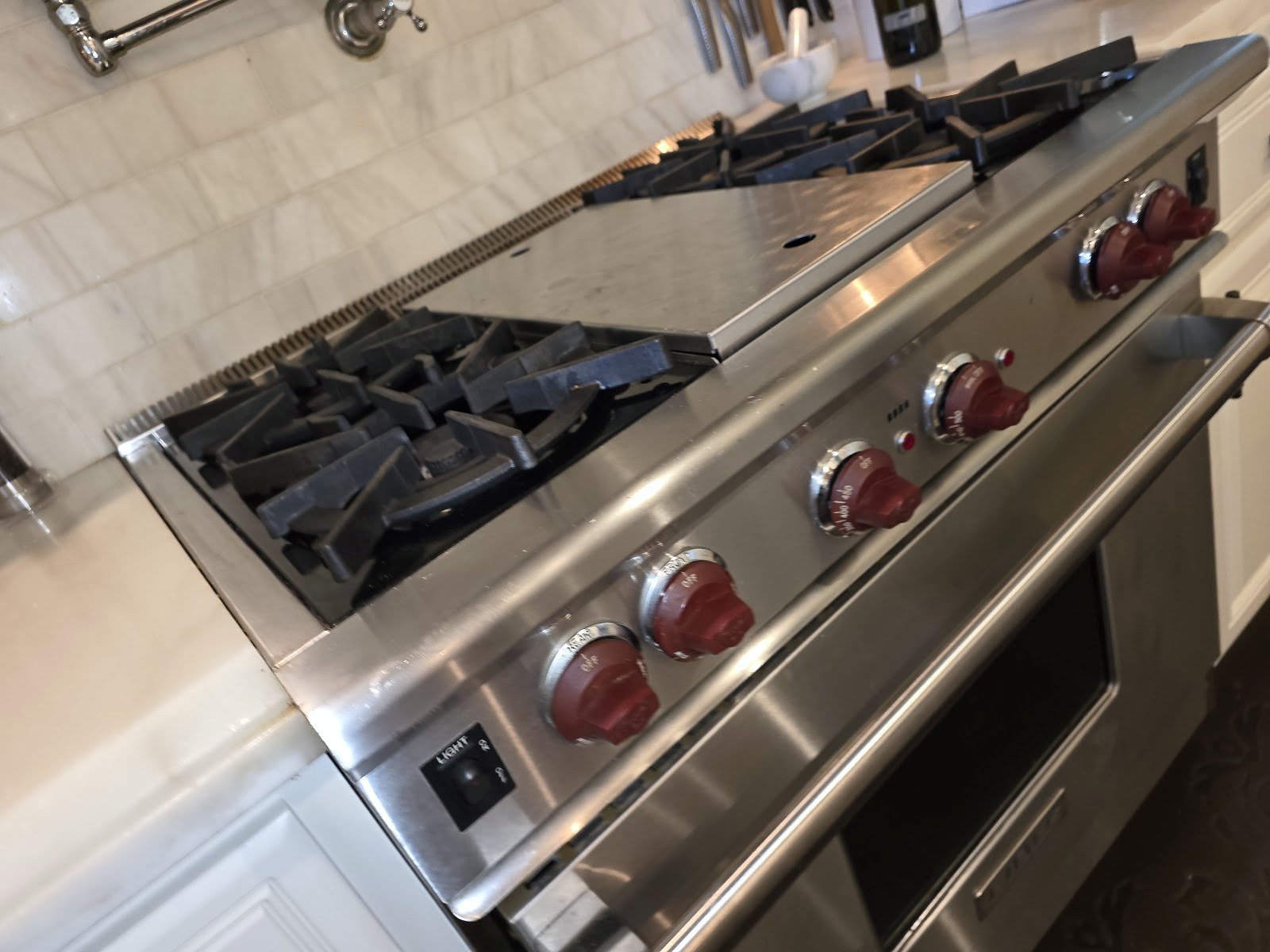 Burner grates and red knobs on a professional-style gas range